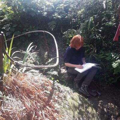 Artist sketching at Sancreed Well, West Cornwall.
