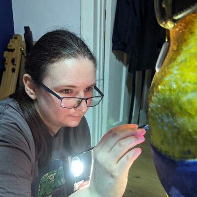 Artist Alex Devlin painting the chest of a Guide Dog Statue