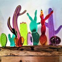 Various brightly coloured cacti mounted on rustic driftwood - fused glass.