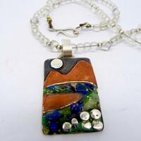 Mixed metal pendant with lapis lazuli and peridot chips on a rock crystal and opalite necklace.