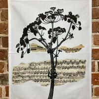 tea towel with a woodblock print of hogweed on music manuscript collage 