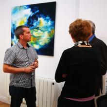 Alexander discussing his work during an exhibition.
