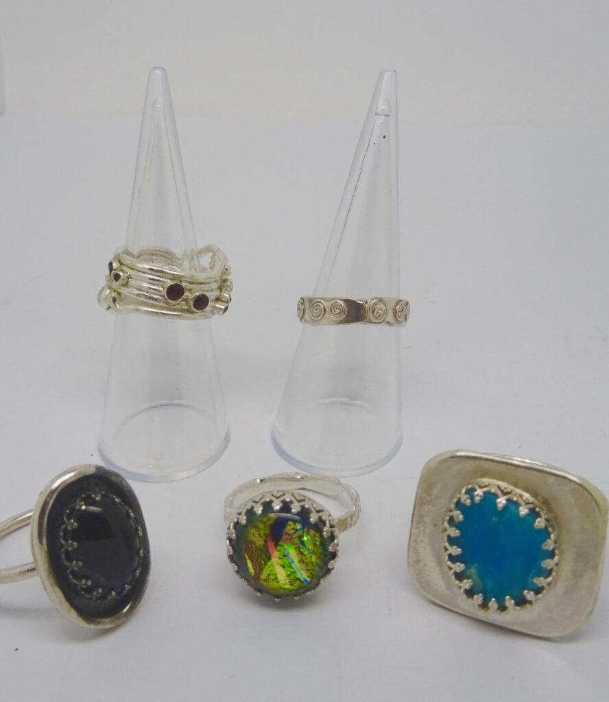 Sterling silver rings set with onyx, garnets and amethysts, dichroic glass and turquoise.