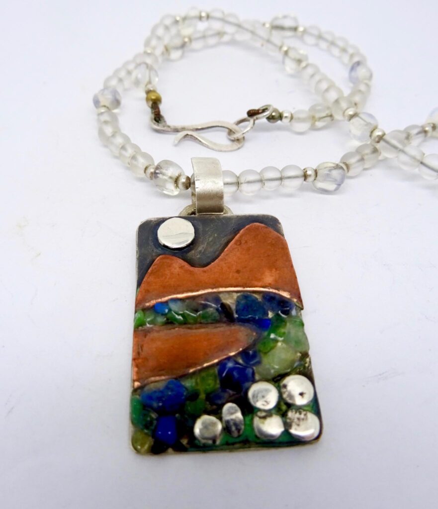 Mixed metal pendant with lapis lazuli and peridot chips on a rock crystal and opalite necklace.