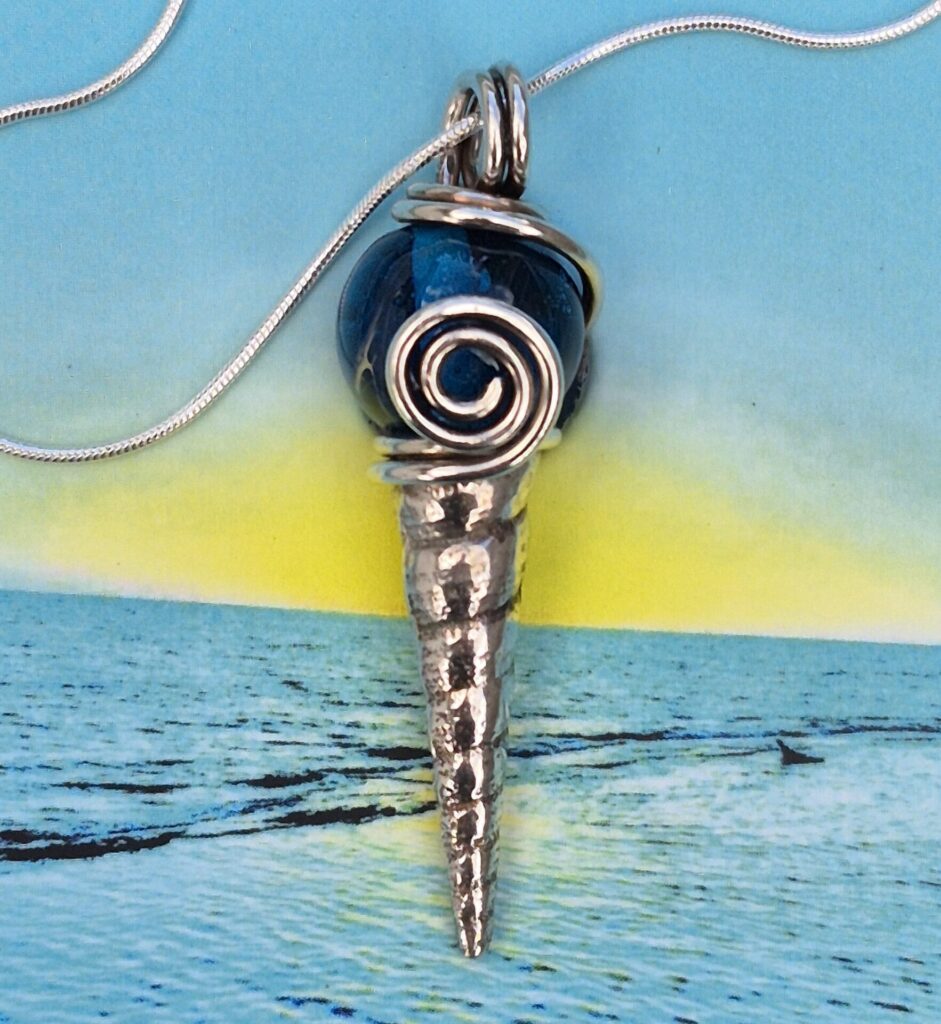 Silver shell with glass blue glass bead