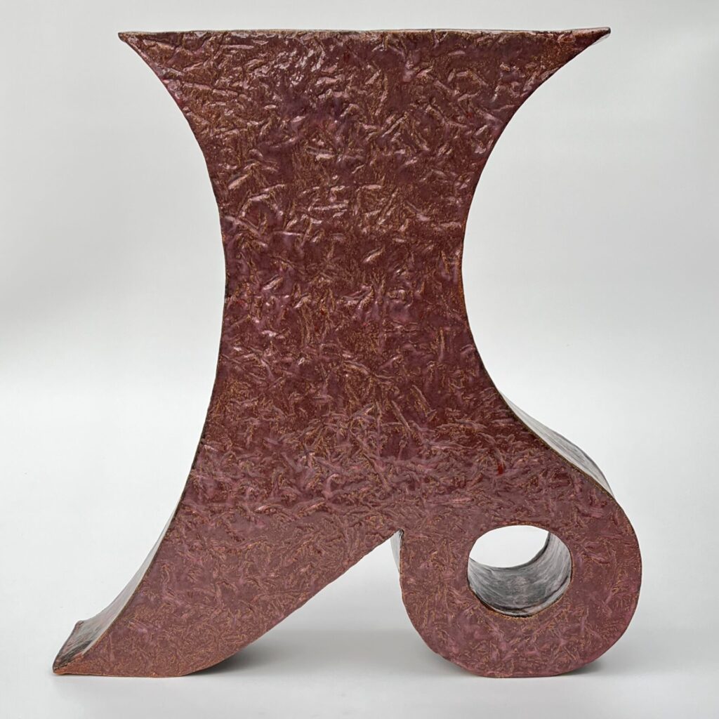 Textured dark pink vessel curved inward at the sides with a pierced rounded heel.