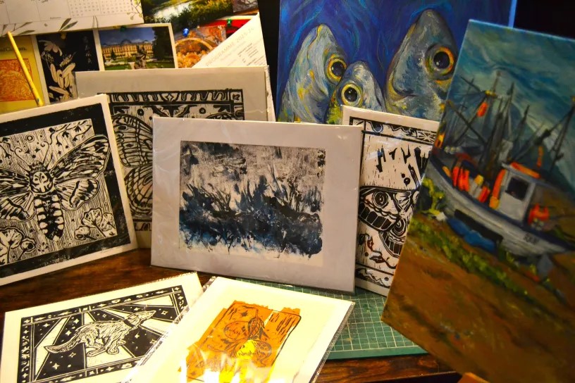 A collection of prints and paintings in both vibrant colours and solid inky blacks based around nature, ranging from fish to pomegranates