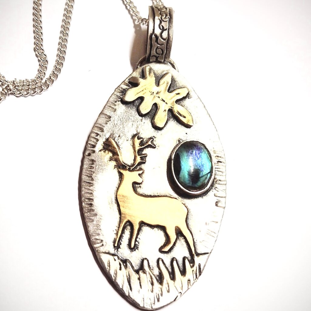 Mixed metal pendant. Gold plated stag with abalone shell.