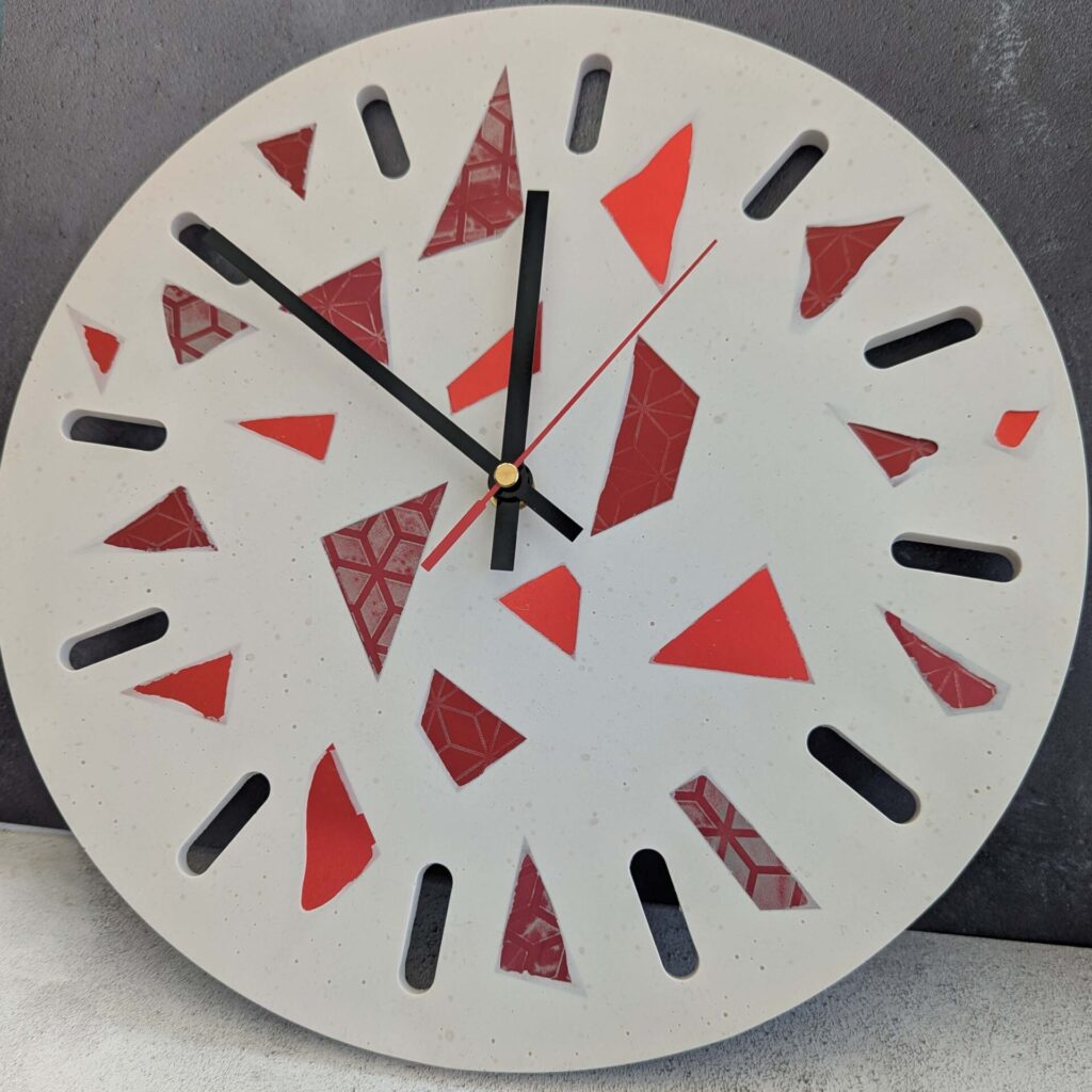 Clock made from jesmonite material with hand dyed terazzo style red aluminium pieces embedded
